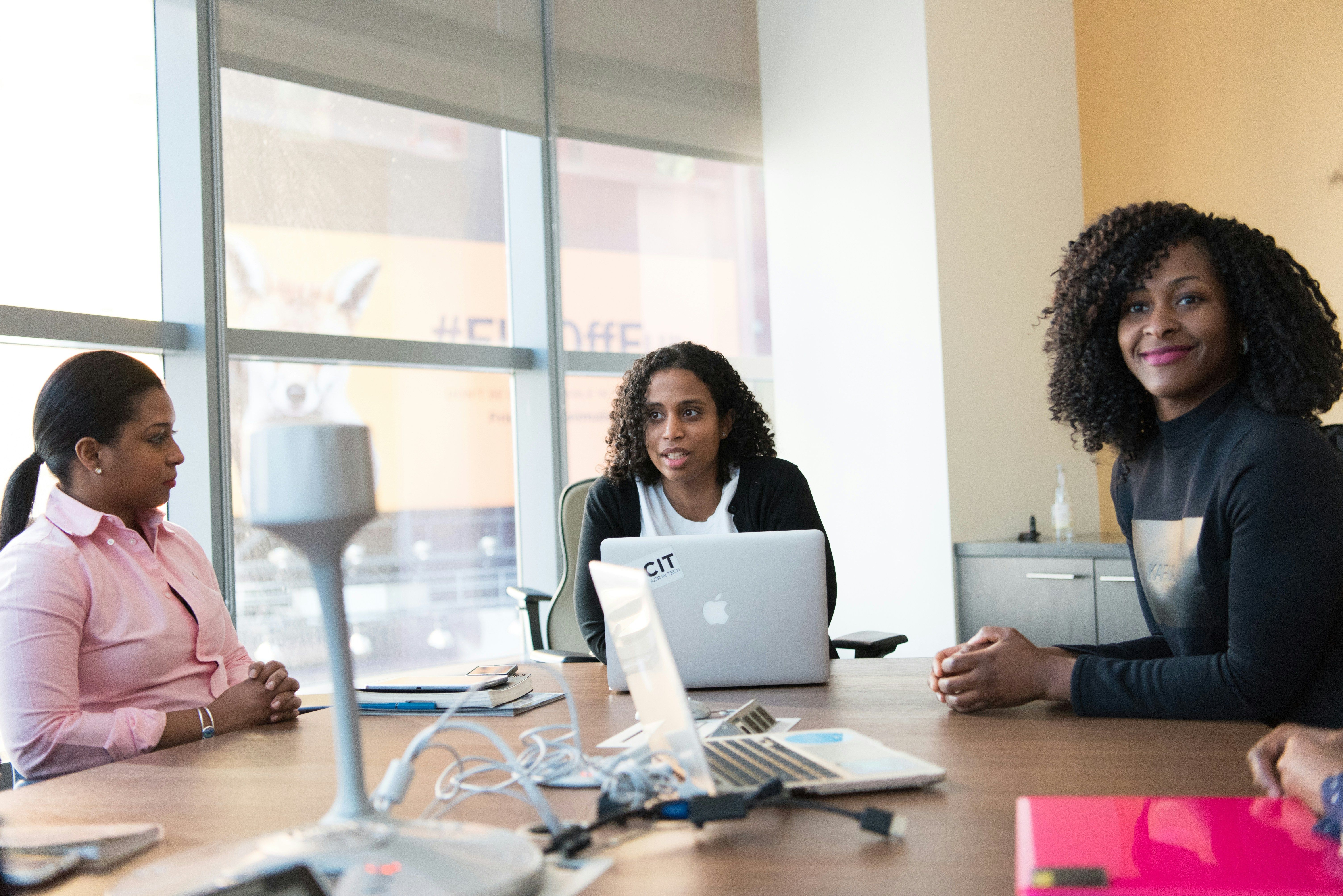 colleagues in a office discussing Best CMS