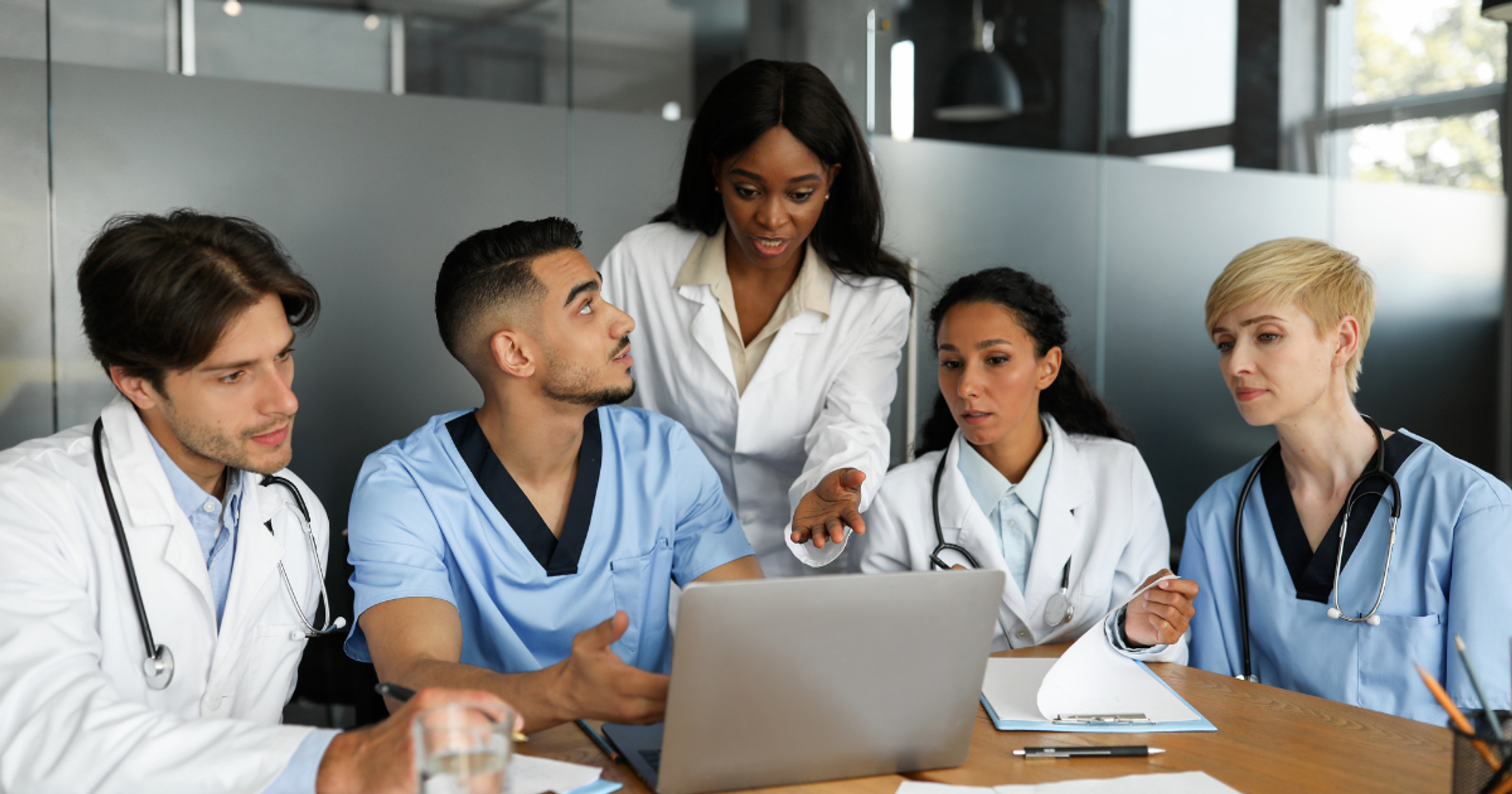 Puzzled Doctors Discussing Medical Cases, Using Laptop -  Chatbot Use Cases